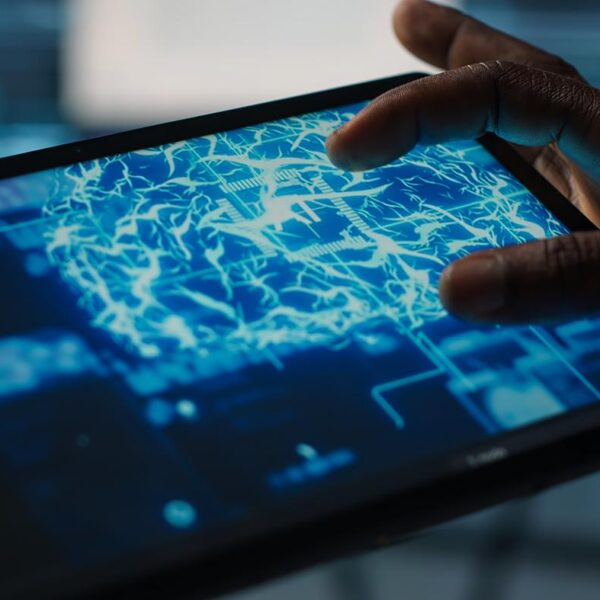 Close up of computer scientist in data center uses AI on tablet, verifying compliance of racks. IT expert using artificial intelligence on device to optimize resource utilization, camera A